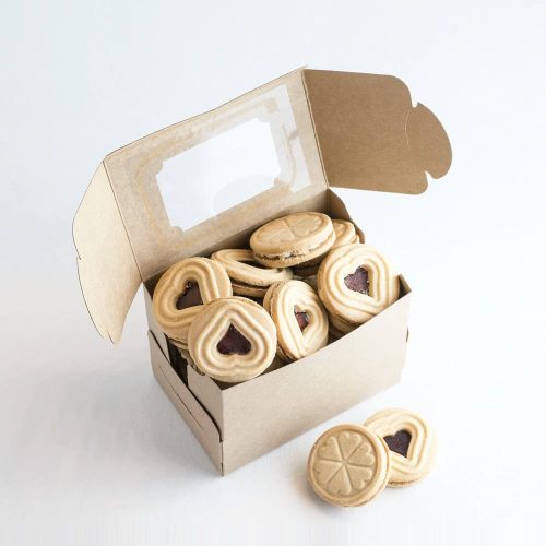 Delicious heart-shaped linzer cookies with jam inside in a bakery gift box.
