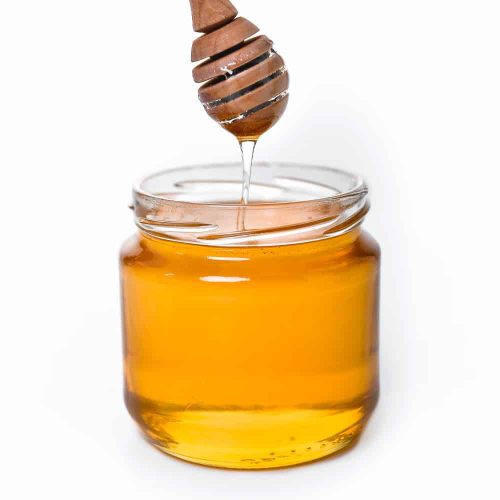 Pure honey in glass jar with honey dipper, natural sweetener and health benefits.