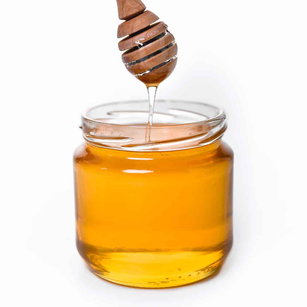 organic-honey Pure honey in glass jar with honey dipper, natural sweetener and health benefits.