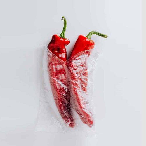Red bell peppers in a plastic bag for fresh produce storage.