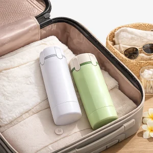 Premium 4-in-1 leak-proof travel toiletry dispenser bottle packed in business traveler luggage with refillable bottles for shampoo, lotion, body wash, and travel essentials.