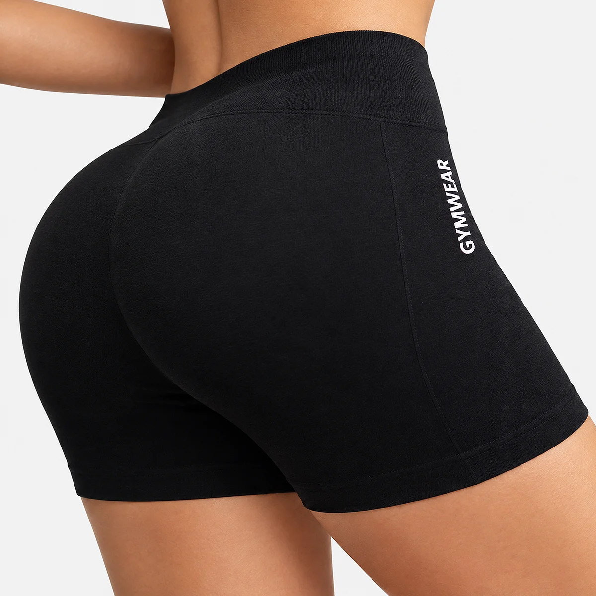 Rear view of a woman wearing black Acuvick high-waisted fitness shorts with a scrunch bum lifting seam and white GYMWEAR text on the side.