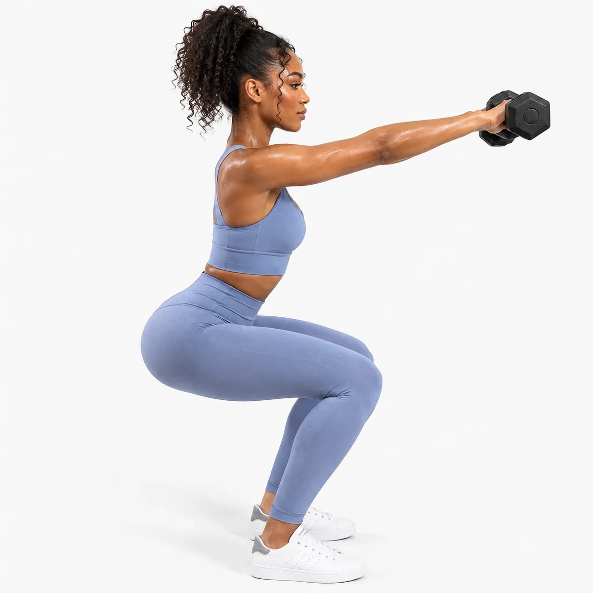 Woman in Tempest Blue high waisted criss cross back leggings two piece workout set doing squats with dumbbells