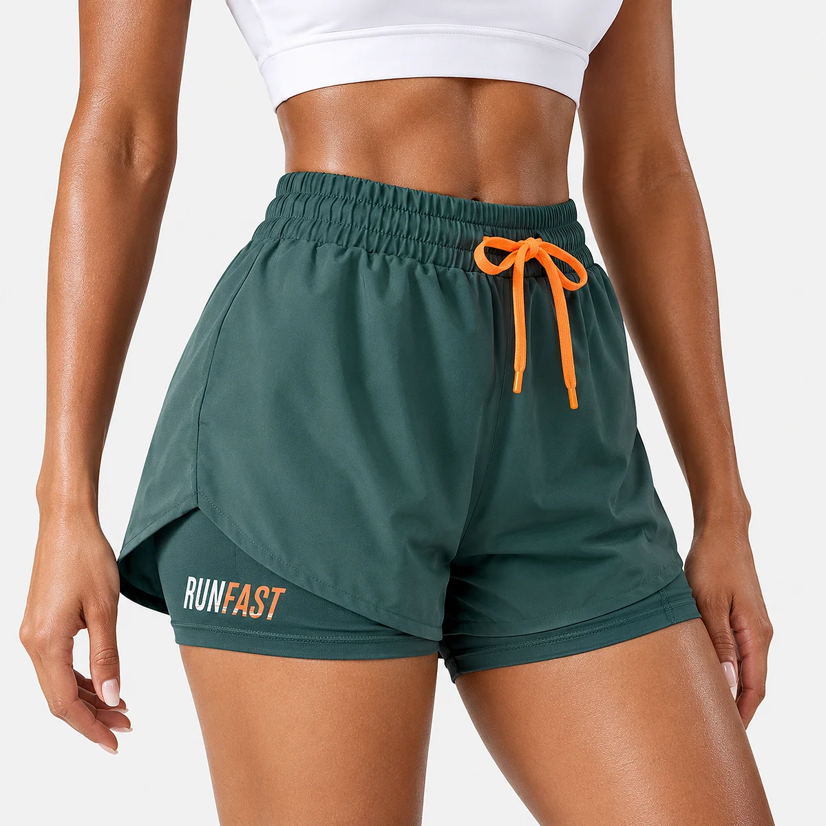 Alt: " Women’s High-Waisted Running Shorts product image – Acuvick " Close-up front view of a woman wearing teal green 2-in-1 women's running shorts featuring an elastic high-rise waistband and a tied bright orange drawstring.